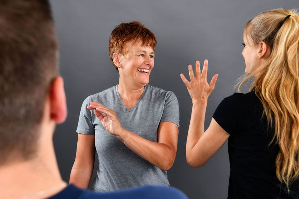 Teilnehmende führen koordinative Übung in Gruppensituation mit Trainerin durch